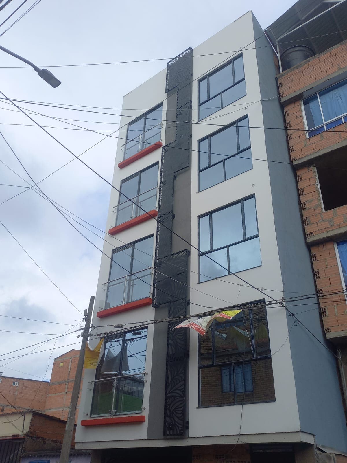 Edificio multipiso con balcones y fachada metálica decorativa
